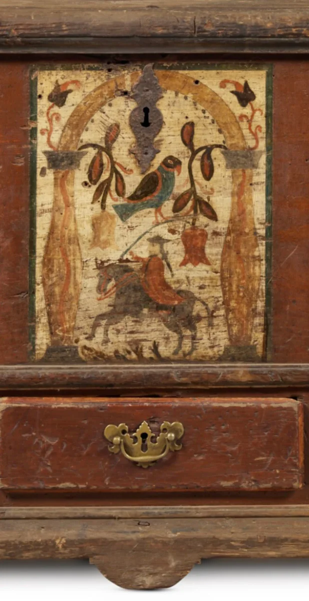 Close detail of an aged painted antique chest showing original color, surface wear, and decorative craftsmanship