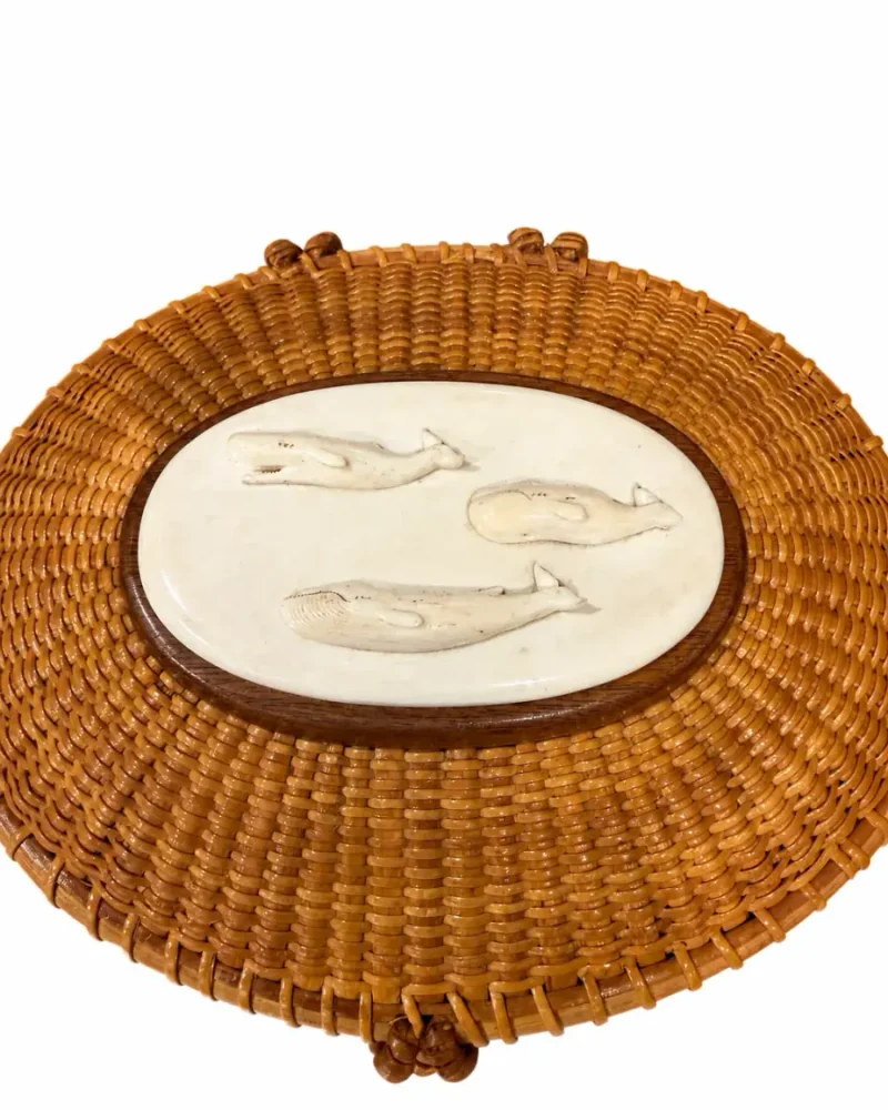 Close detail of the Nantucket lightship basket carved panel with three stylized whale forms